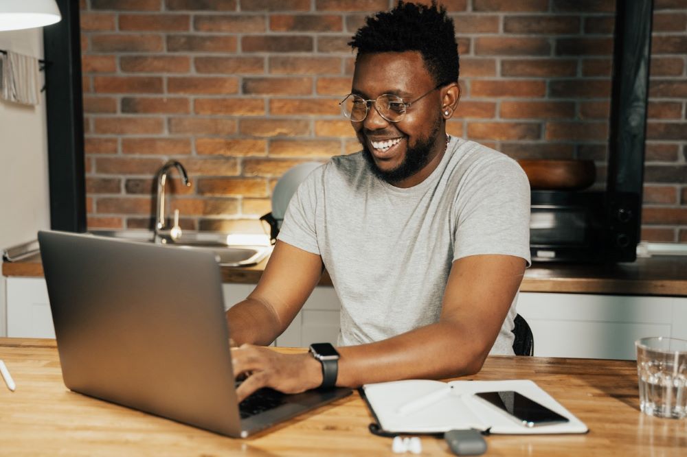 A man at his laptop finding a great swipe - swipe file for association marketers