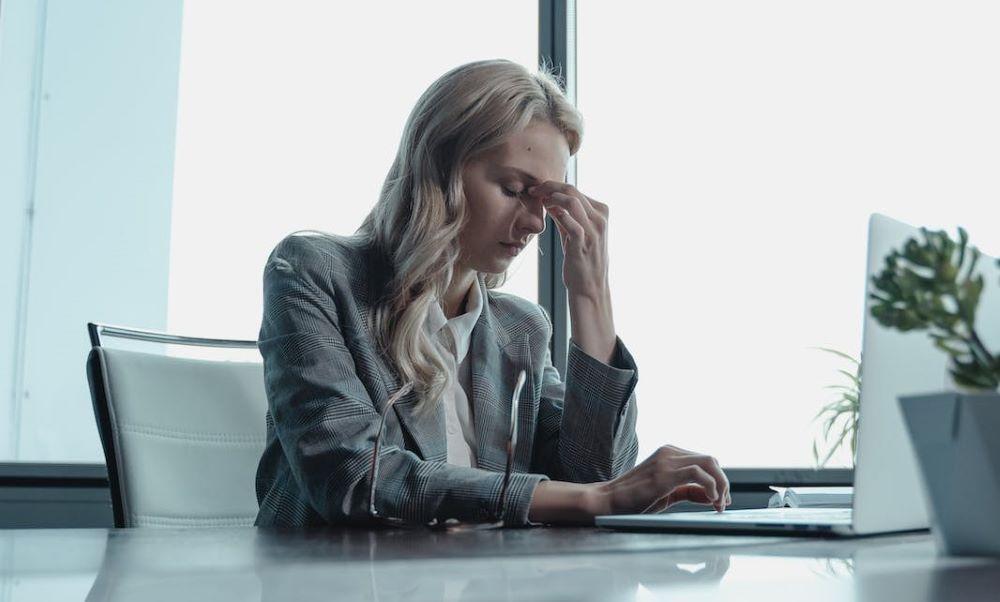 stressed woman at work at the cusp of a mental health crisis