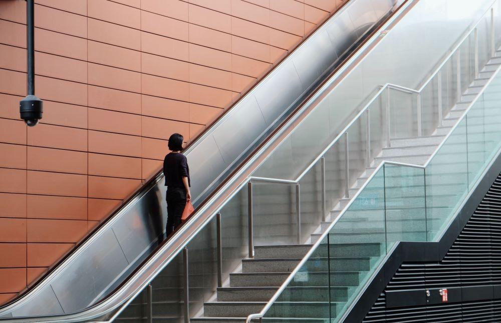 decline in conference attendance - sole figure on a convention center escalator