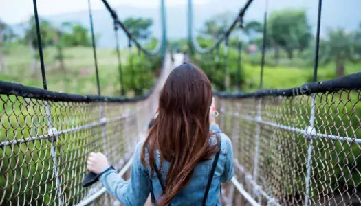 courageous woman walking over scary suspension bridge - pandemic’s impact on associations